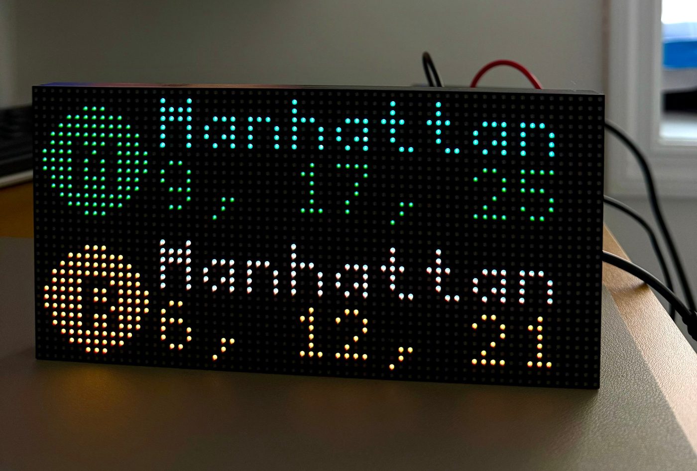 The LED clock on a desk showing the next Manhattan-bound trains on two lines, in minutes